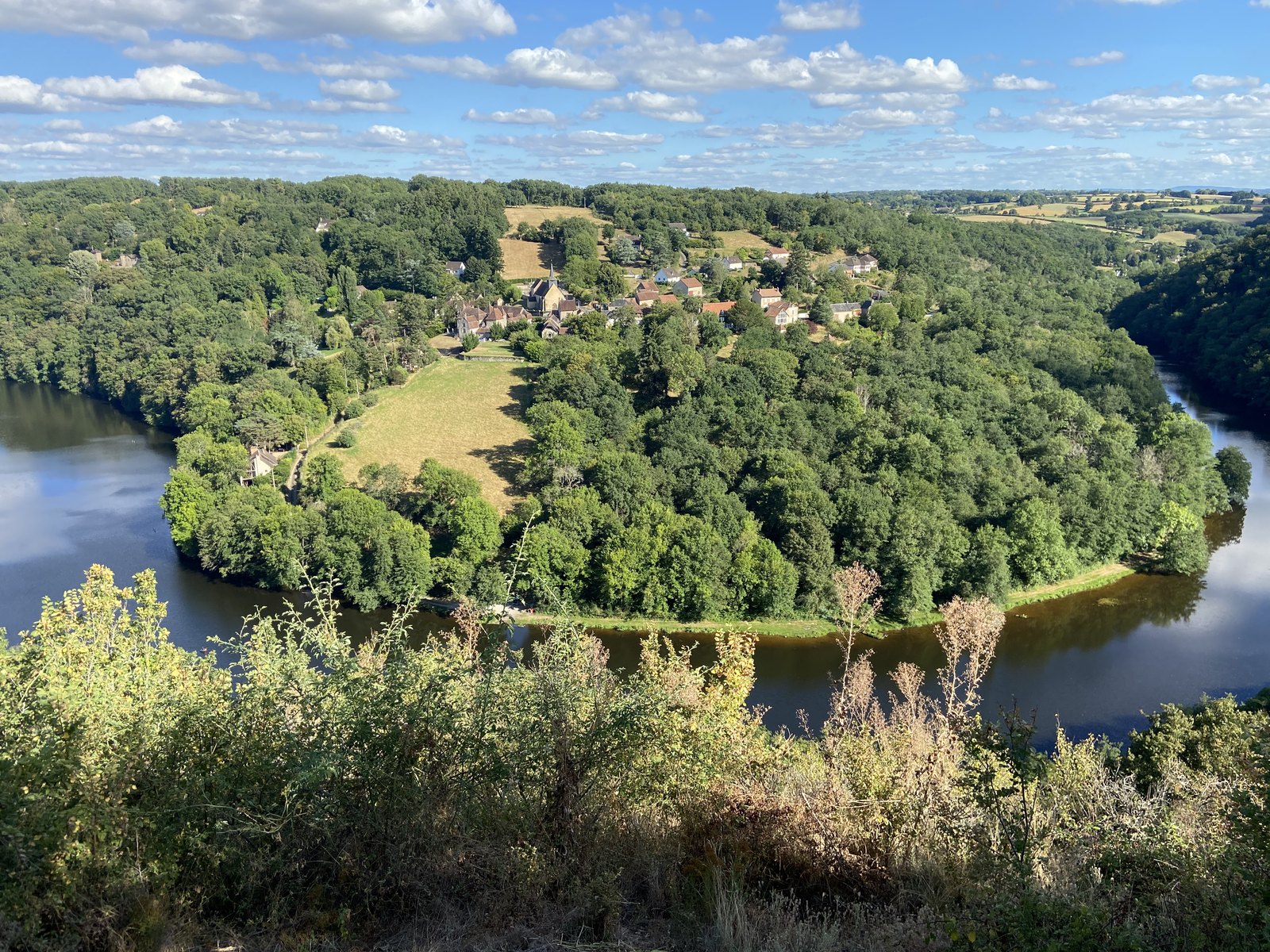 La boucle du Pin : la Creuse enserre un promontoire boisé coiffé d'un hameau, vu depuis le point de vue en surplomb