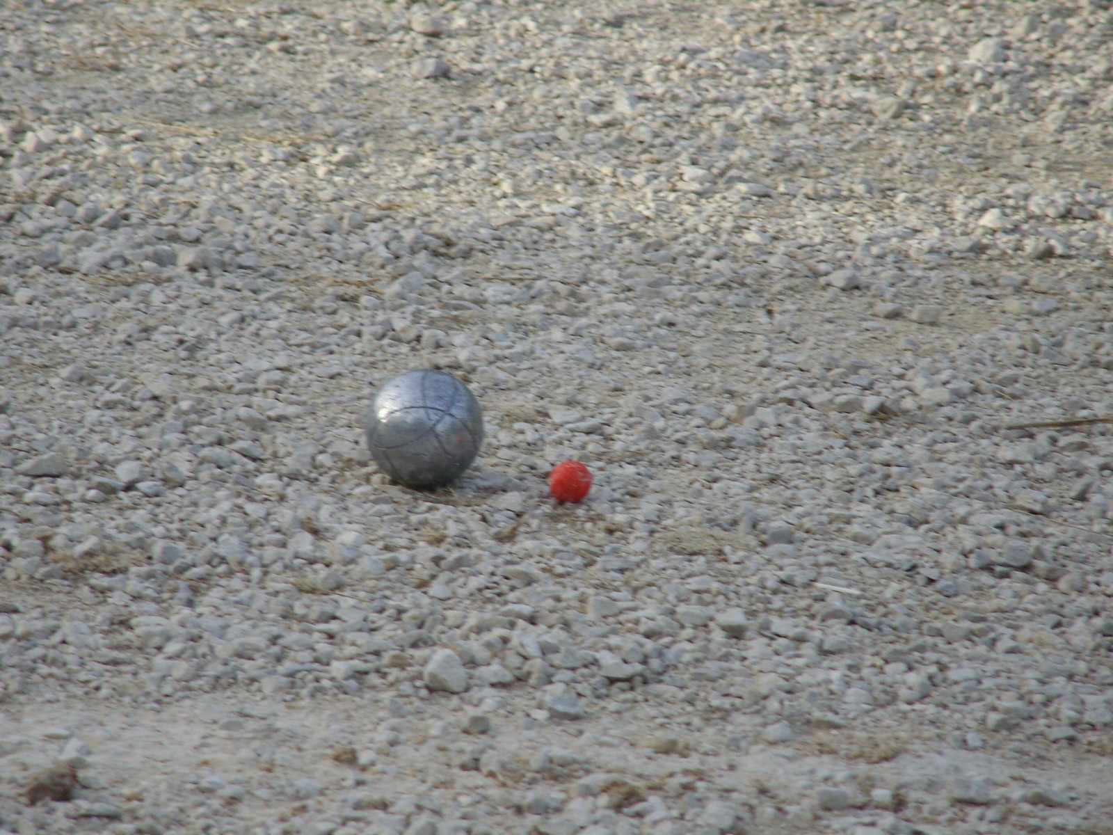 Terrain de boules de 9 La Roche, boule et cochonnet sur le gravier