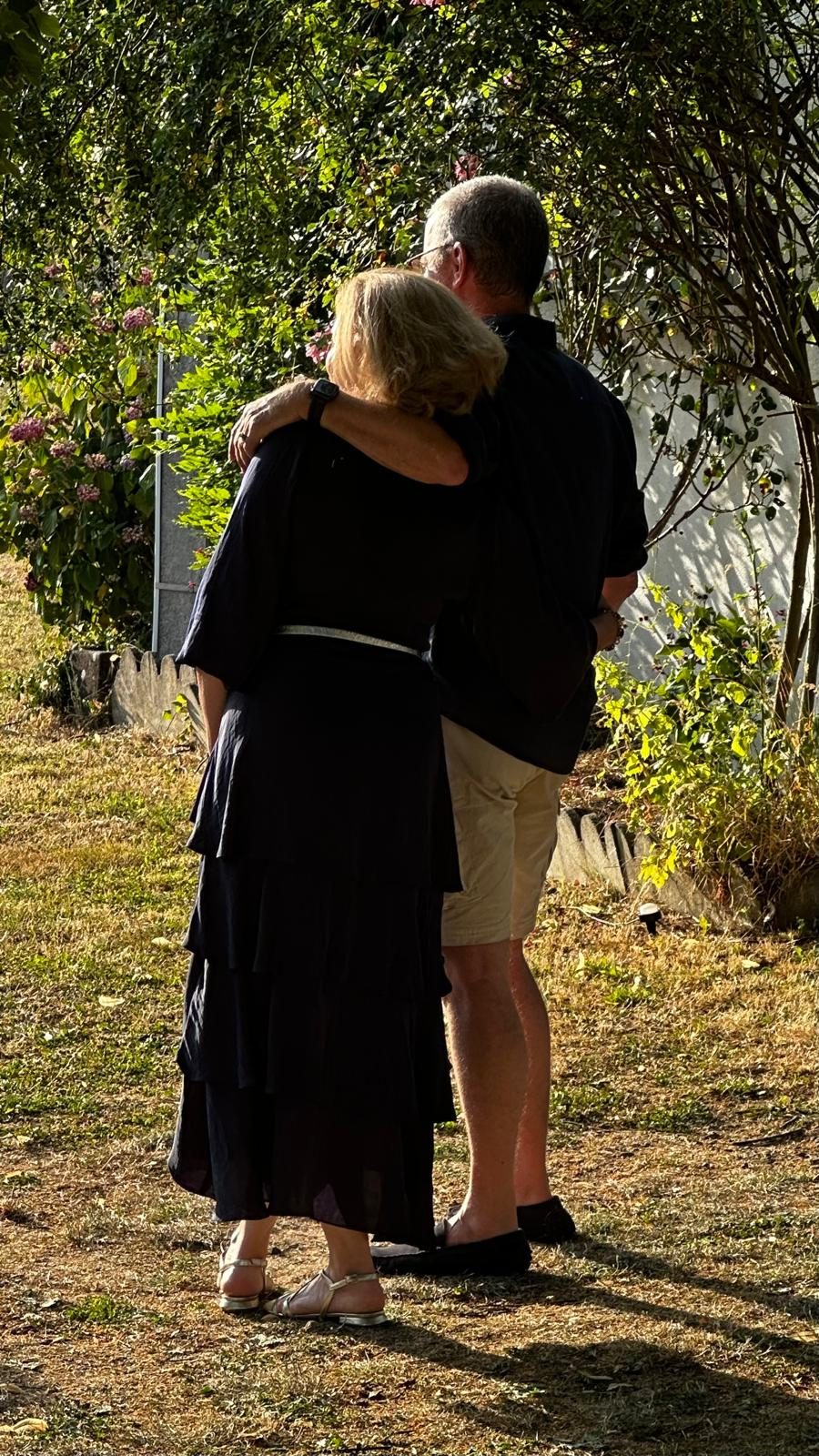 Carole et Xavier Dôme, de dos, enlacés dans un jardin