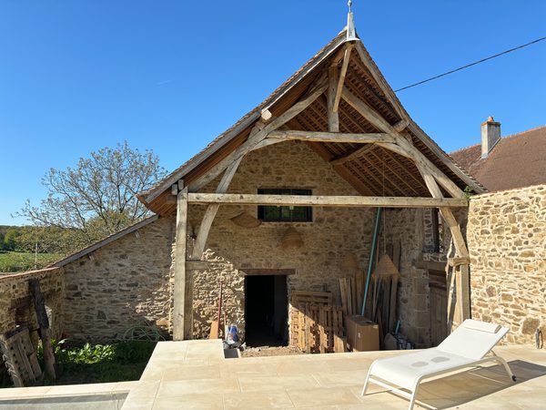 Charpente en chêne apparente terminée, terrasse et piscine achevées