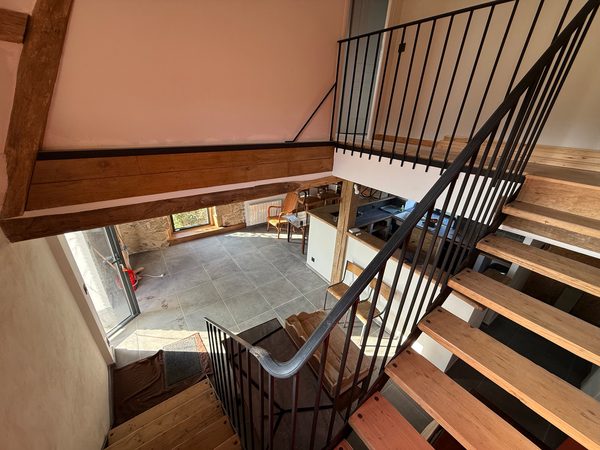Escalier et pièce à vivre achevés, vus depuis une mezzanine
