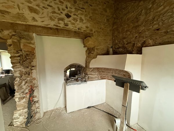 Four à pain restauré, intégré dans un mur enduit de blanc